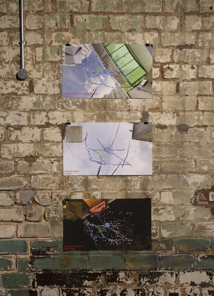 prints of flight paths and panorama views displayed on a brick wall